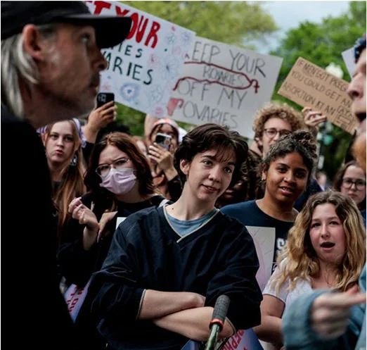 group of people rallying and watching 2 people arguing